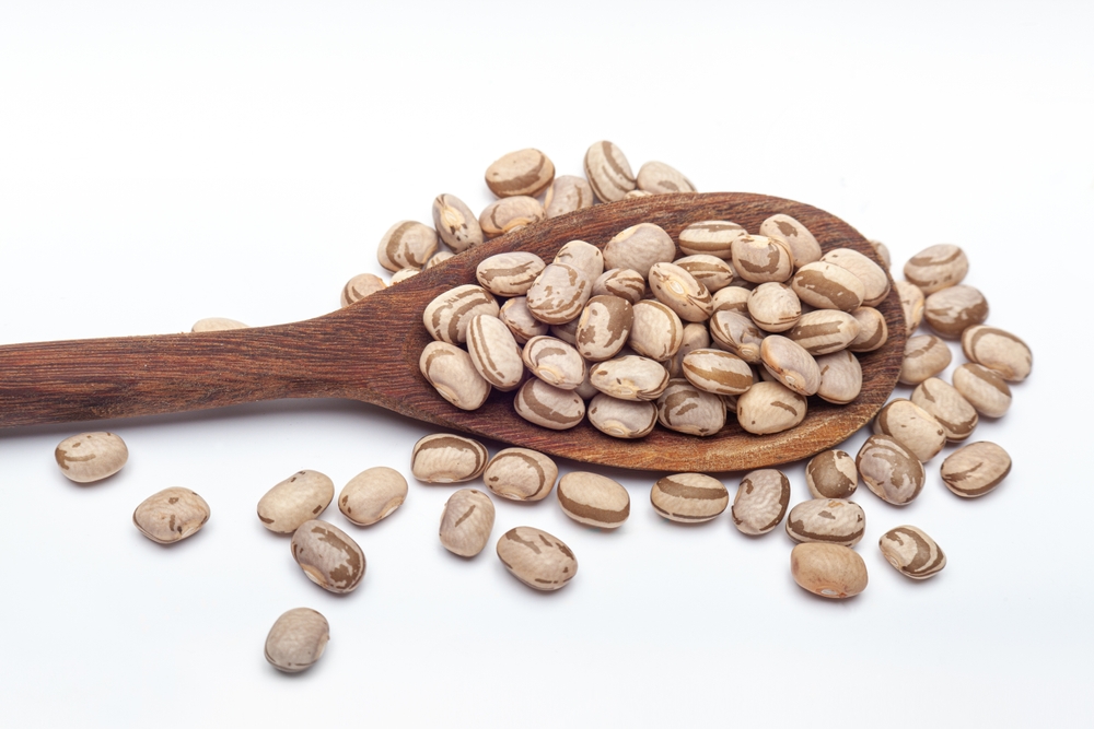 Close-up,Of,Dried,Carioca,Beans,On,Wooden,Spoon.,Isolated,White
